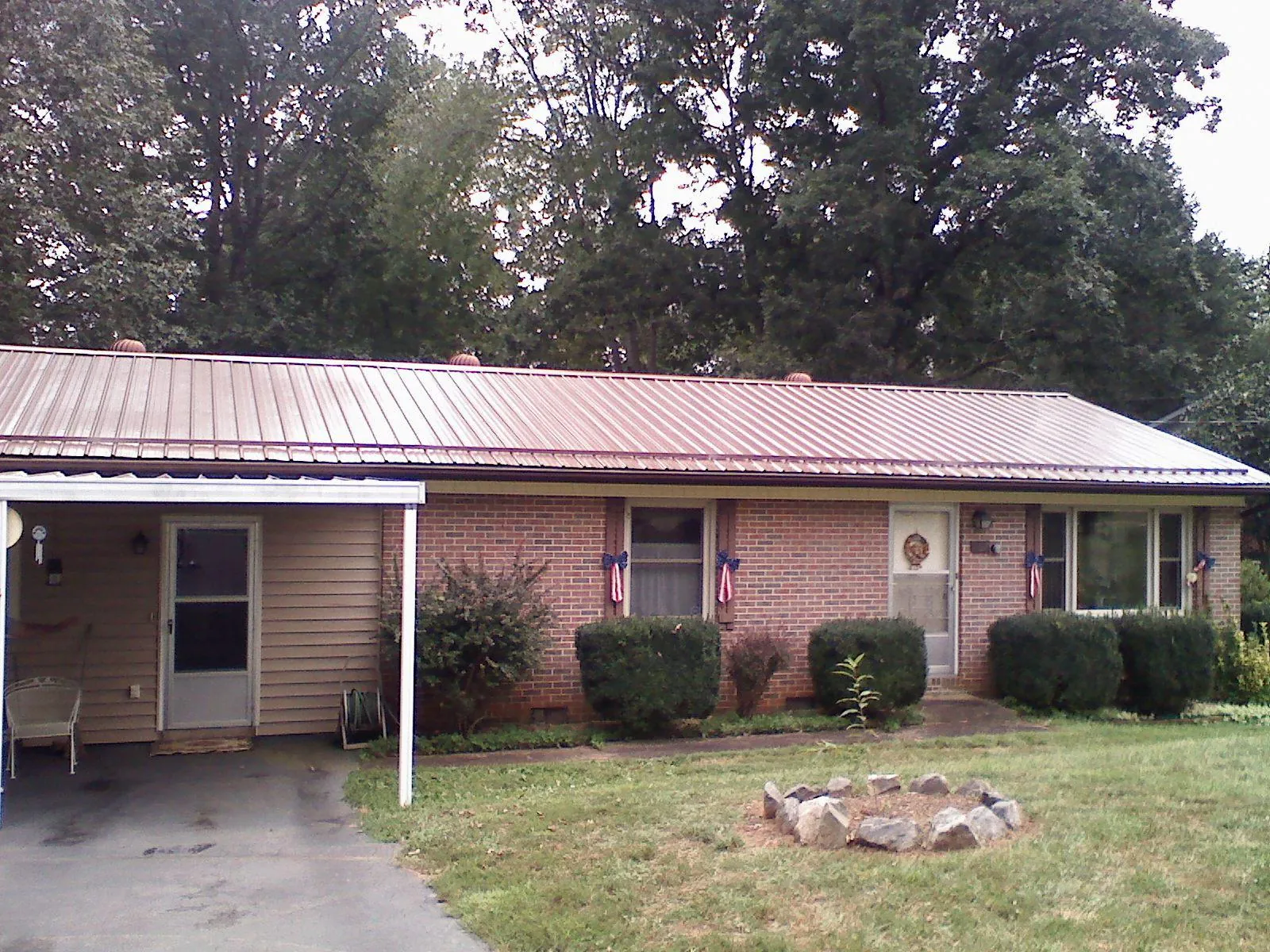 Bronze metal roof and carport on a brick ranch home — Roof Repair work by our crew in Seymour